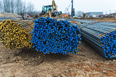 Photo of construction metal rods on the background of a construction site and equipment on the street