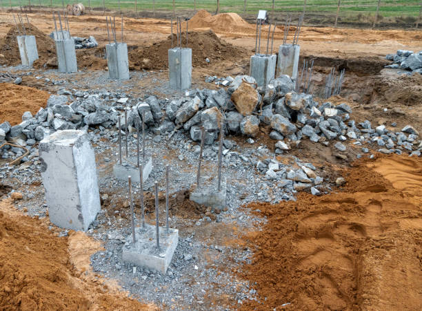 foto de barras metálicas de construção em pilares de concreto contra o fundo de um canteiro de obras na rua - basement concrete construction form - fotografias e filmes do acervo