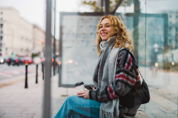 Young woman using smart phone at bus station