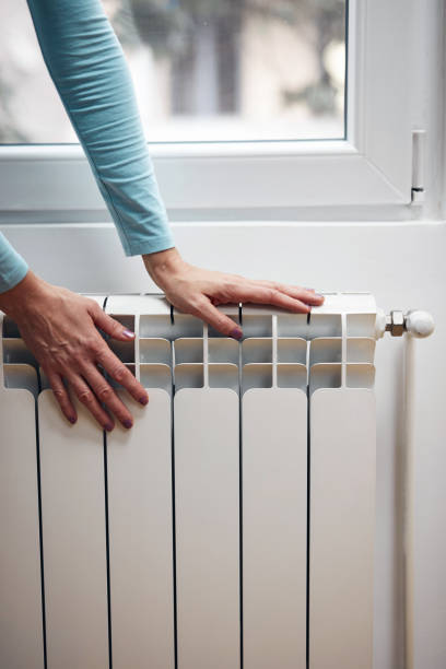 istock Woman heating her hands on the radiator during cold winter days. 1355091412