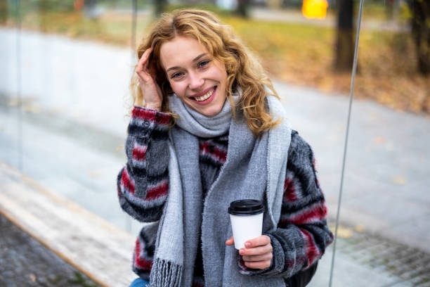 istock Young woman with coffee cup smiling outdoors 1355091429