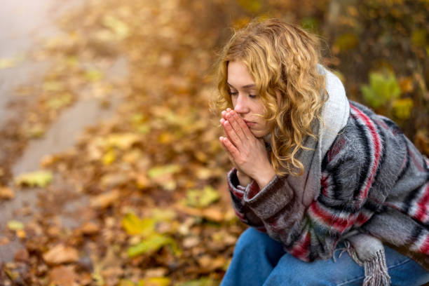 istock Depressed young woman sitting on bench in a public park 1355092041