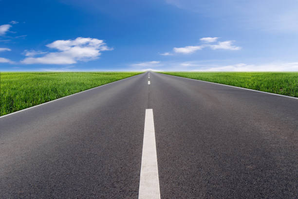istock Asphalt road with green field and blue sky 1355092371