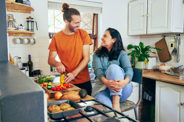 istock Shot of a young couple talking while dinner is prepared 1355092610