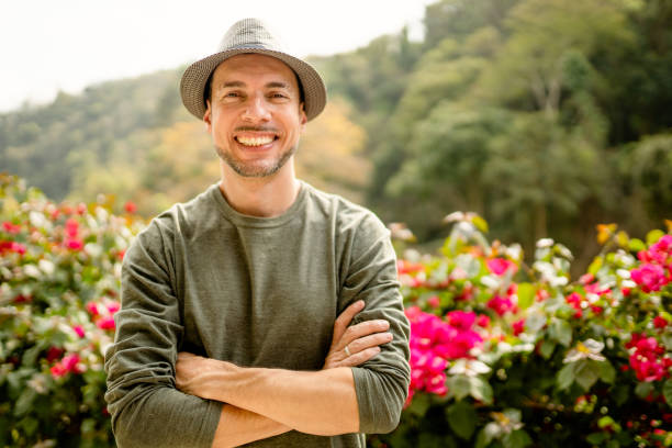 istock Stylish young man smiling while standing with his arms crossed outside 1355092849