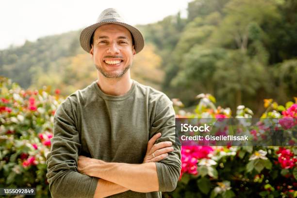 Stylish Young Man Smiling While Standing With His Arms Crossed Outside Stock Photo - Download Image Now