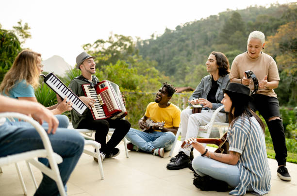 diverse group of band members jamming outside with a variety of instruments - jam up imagens e fotografias de stock