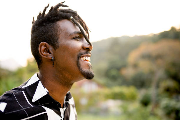 istock Laughing young man with dreadlocks standing outside in the summertime 1355093173