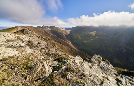 Rocky crag with distant views of Hopegill Head, Sand Hill and Grasmoor in the English Lake District, UK.