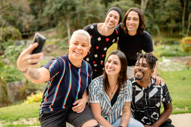 istock Diverse young friends smiling and taking selfies outside in summer 1355093790