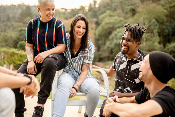 istock Diverse young friends talking and laughing together outside in summer 1355093814