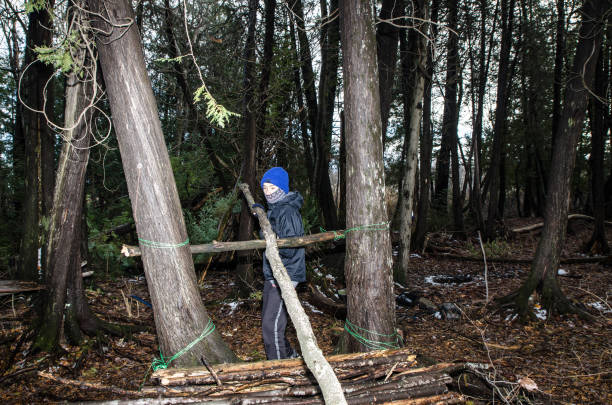 istock Boy building a shelter in the woods 1355095856