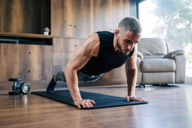 istock Muscular Athletic Young Man Training For Body Building At Home 1355095924