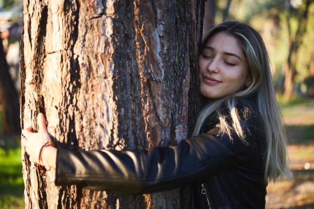 istock young woman reflects feeling hugging tree to protect forest in sunlight 1355096799