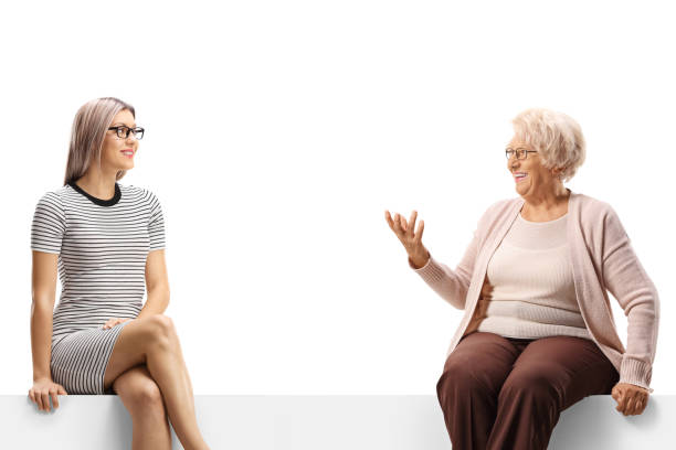 istock An elderly and a young woman sitting on a panel and having a conversation 1355097319