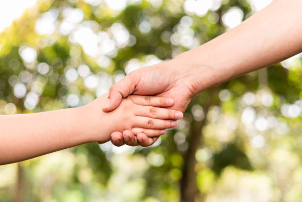 istock Father holding son's hand in a public garden 1355097583