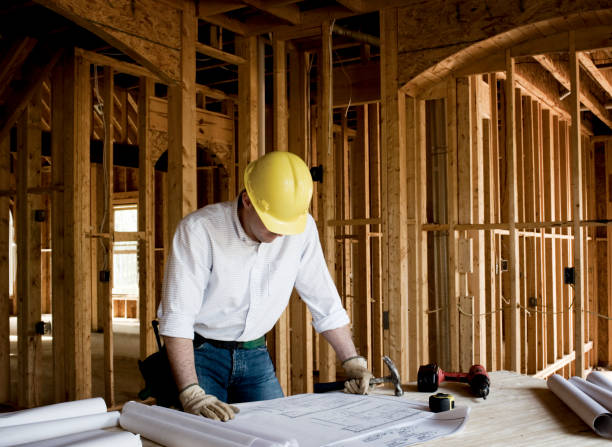 istock Home Builder looking at Blueprints of House. 1355098325