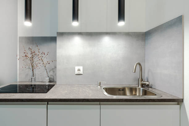 istock Minimalistic compact kitchen in a small apartment with elements of concrete, black and white 1355101040
