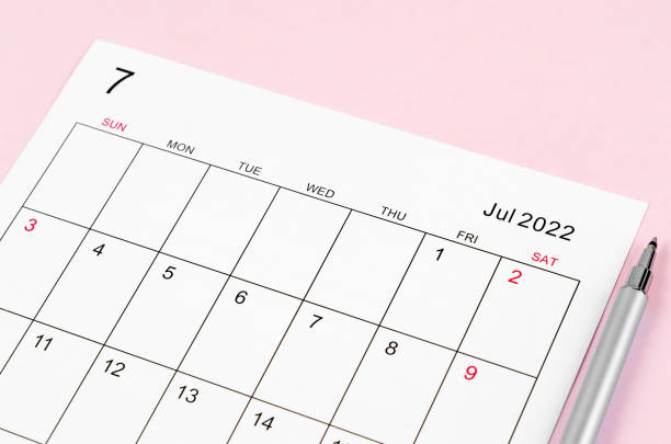 istock June 2022 calendar sheet with pen on pink background. 1355101163