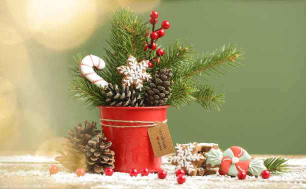 Festive natural, zero-waste, plastic-free, Christmas decoration. DIY winter holidays home decor made of traditional homemade biscuits, fir branches, pine cones and red berries.