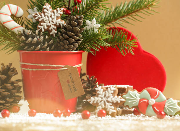 Festive natural, zero-waste, plastic-free, Christmas decoration. DIY winter holidays home decor made of traditional homemade biscuits, fir branches, pine cones and red berries.