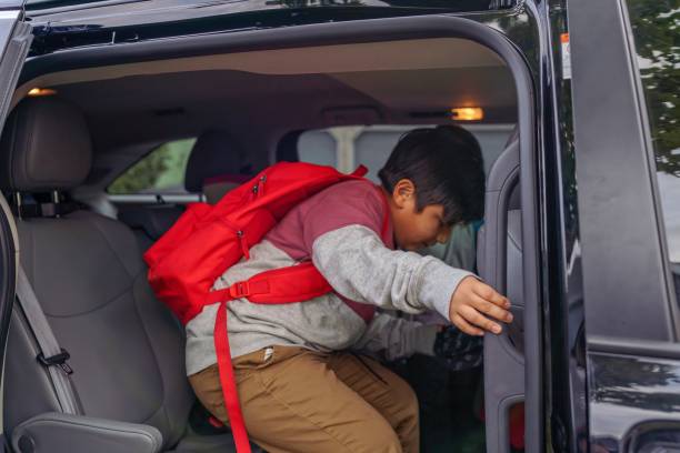 istock Elementary age boy getting in car to go to school 1355105844