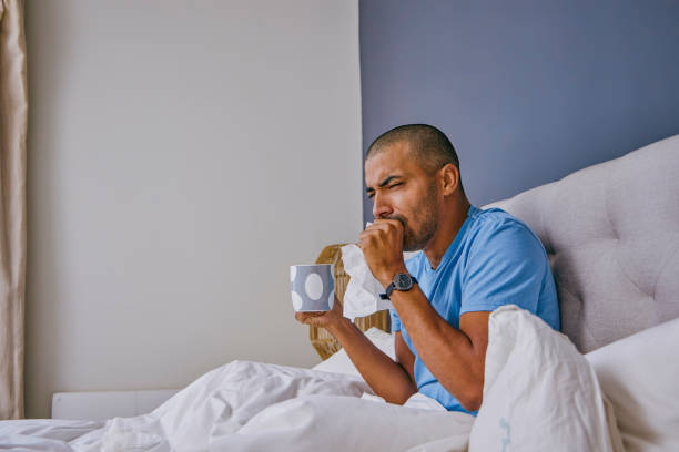 istock Shot of a young man suffering from a cold at home 1355106280
