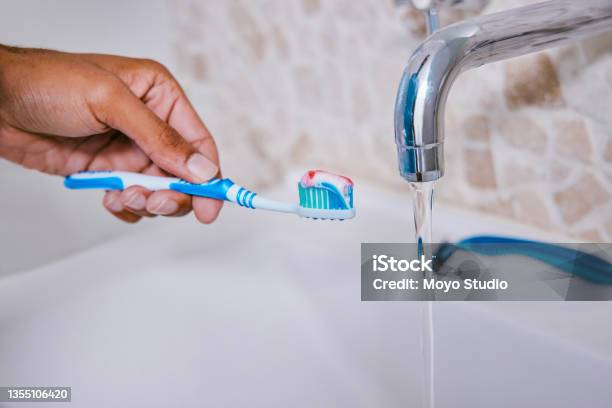 Shot Of An Unrecognizable Person Brushing Their Teeth In A Bathroom At Home Stock Photo - Download Image Now