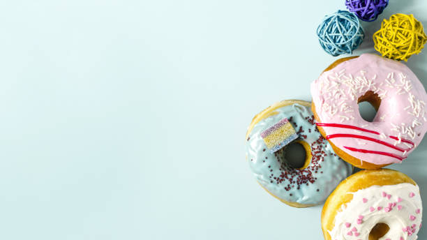 istock Banner fresh bright donuts with colored glaze and decor on a light background. Colorful donuts close-up 1355106617