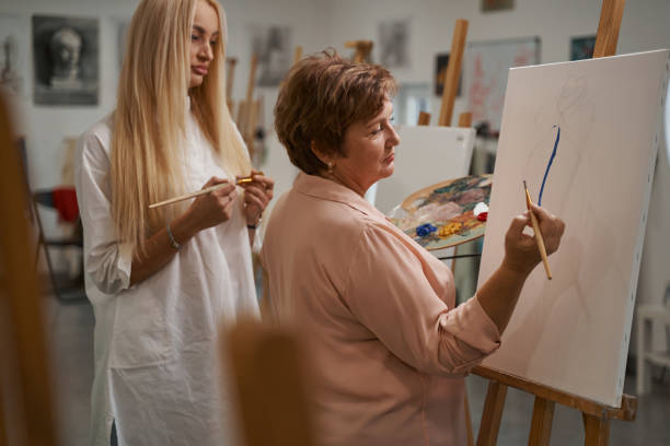 istock Young teacher of art consulting her student 1355107012
