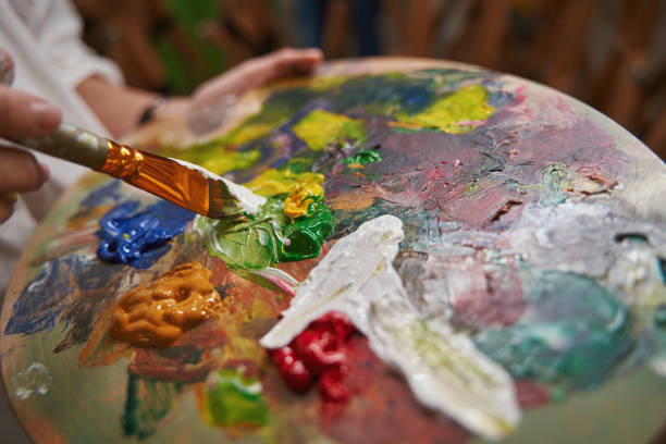 istock Focused photo on artist using brush for drawing 1355107078