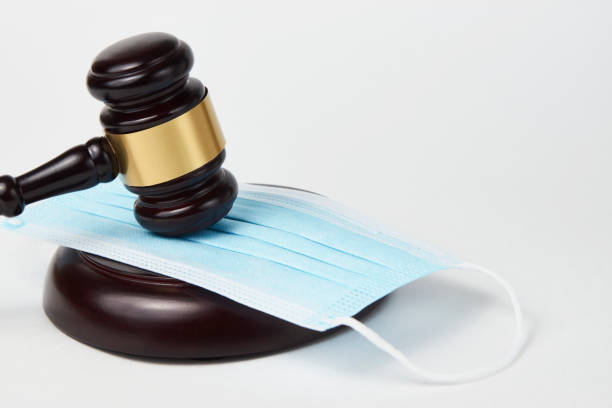 istock Judge gavel and medical protective mask on a white background 1355108413