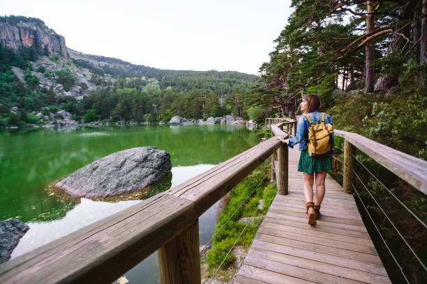 Panoramic view of unrecognizable woman walking on pathway isolated with backpack.
