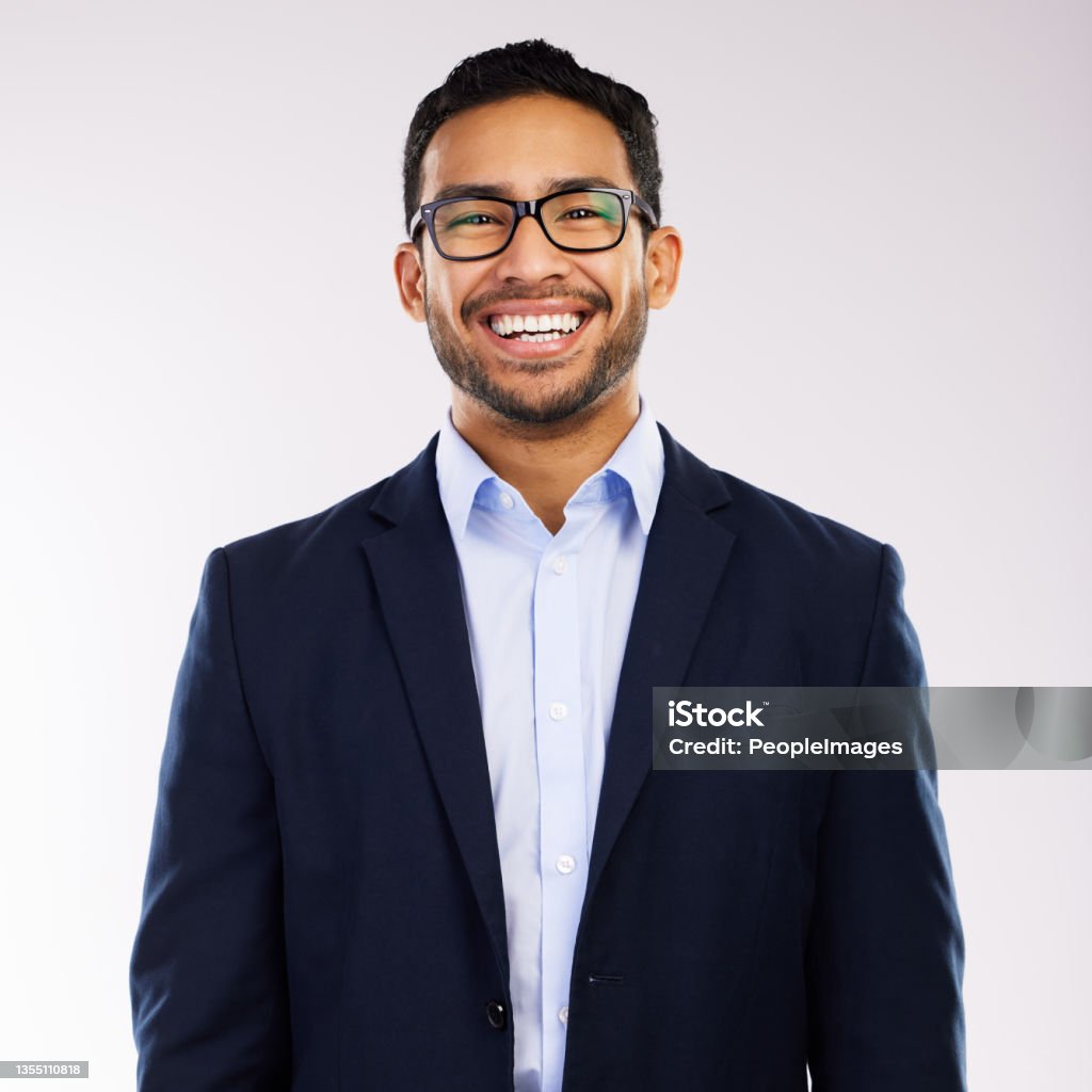 Studio shot of a handsome and happy young man posing against a grey background Most people are nice when you finally see them Headshot Stock Photo