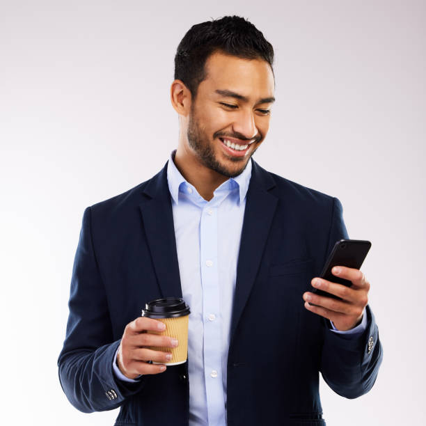 istock Studio shot of a young man using a phone and having coffee against a grey background 1355110827