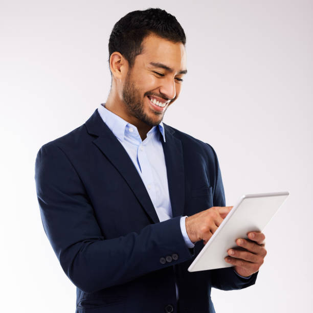 istock Shot of a handsome man standing alone against a grey background in the studio and using a digital tablet 1355110853
