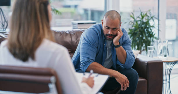 istock Cropped shot of a handsome young man looking thoughtful while sitting in session with his female therapist 1355110890