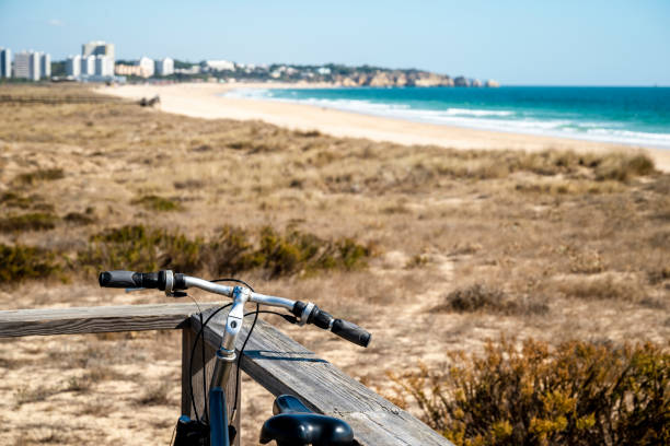 Bike on a wooden coastal boardwalk with a view on the Atlantic Ocean in Alvor, Portugal Bike on a wooden coastal boardwalk with a view on the Atlantic Ocean, Alvor, Algarve, Portugal alvor stock pictures, royalty-free photos & images