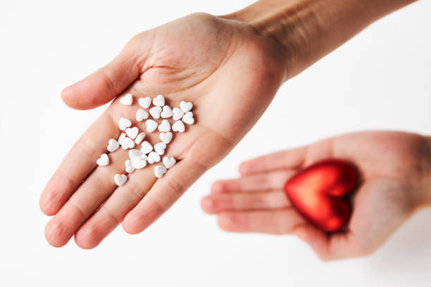 istock Hand with red heart and pills, close-up 1355111846