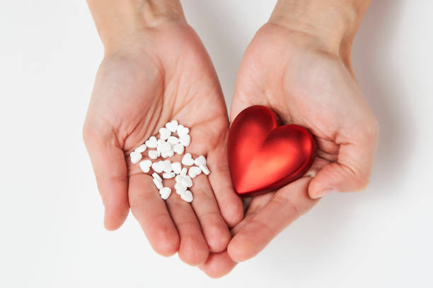 istock Hand with red heart and pills, close-up 1355111853