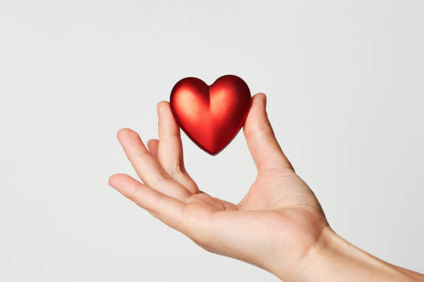 istock Hands holding red heart, close-up, white background 1355111864