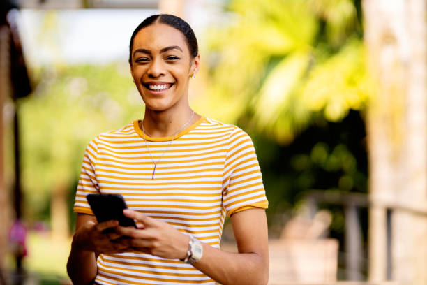 istock Smiling woman sending a text message while standing outside on her patio 1355114178