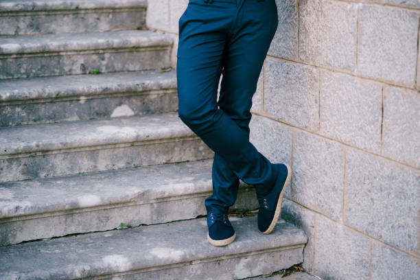 Groom stands on the stone steps, legs crossed