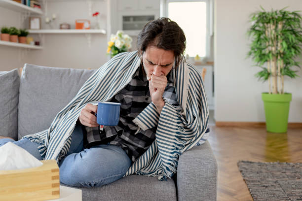 istock Man Wrapped in a Warm Blanket Suffering From Flu 1355115808