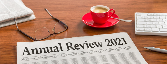 A newspaper on a wooden desk - Annual review 2021