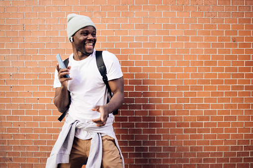 Portrait of a young African American tourist in Madrid enjoying music.