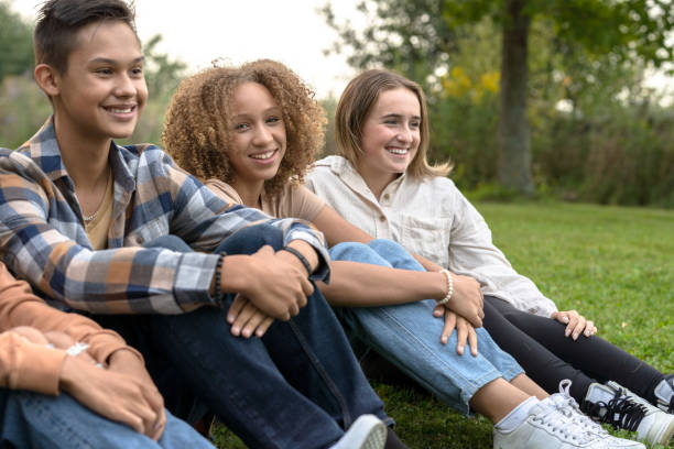 istock High School Students Sitting in a Line Outside 1355122332