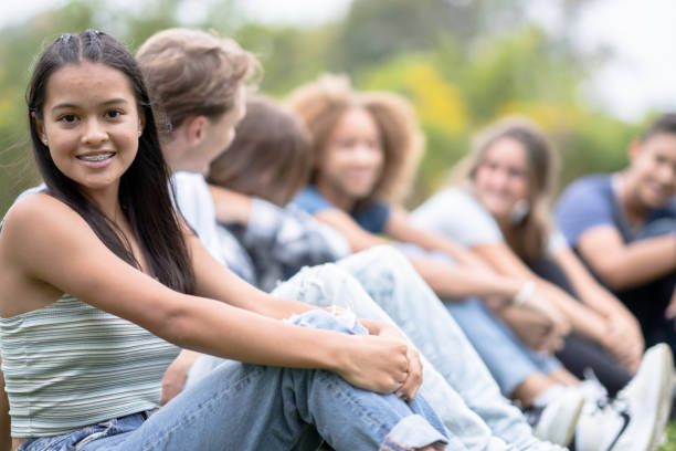 istock High School Students Sitting in a Line Outside 1355122345