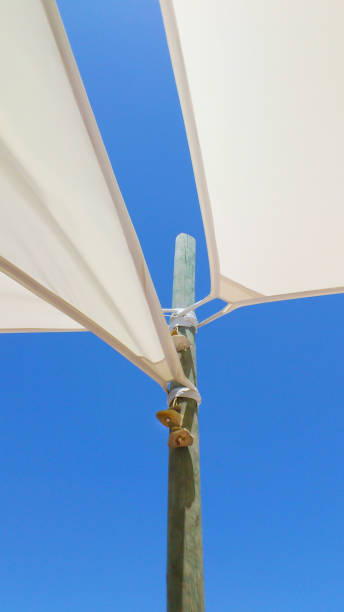 sonnendächer. abstraktion gegen den blauen himmel. holzstütze und canvas-schwitzstoffe. - shade sail awning textile stock-fotos und bilder