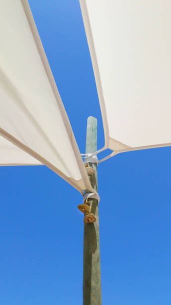 istock Sun canopies. Abstraction against the blue sky. Wooden support and canvas sweat fabrics. 1355123771